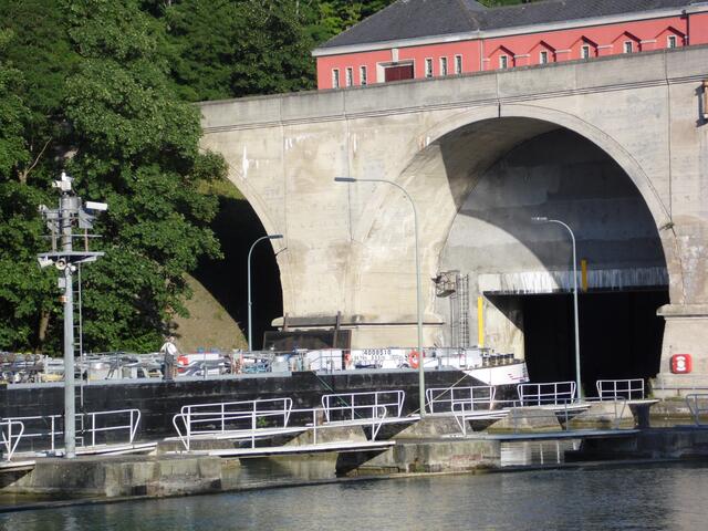 Von der Stadtseite fährt ein großes Binnenschiff durch ein Hubtor in die östliche Schleusenkammer ein.