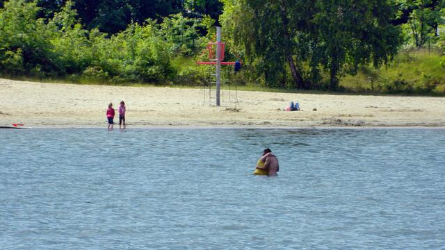Die ersten Badegäste kühlen sich im Wasser
