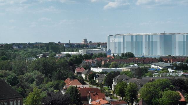Der Blick von der Aussichtsplattform geht über die Werfthalle bis zum Hochhaus (Bildmitte) im Stadtteil Wendorf.