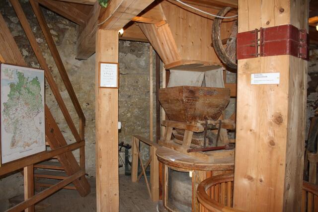 Steinmahlgang mit Plastikscheibe in der Holzbütte damit die Besucher auch richtig schauen können
