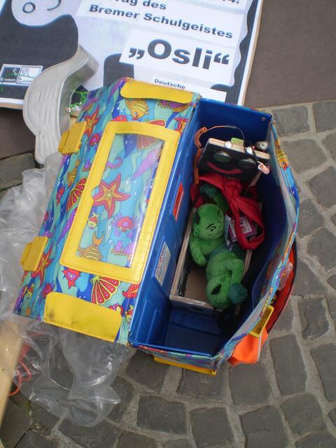 Bremen, 28. Juni 2014: Maskottchen GRÜNHOLD in der "BAKI made in China" in der Schultasche von JAN auf dem Bremer Hanseatenkreuz