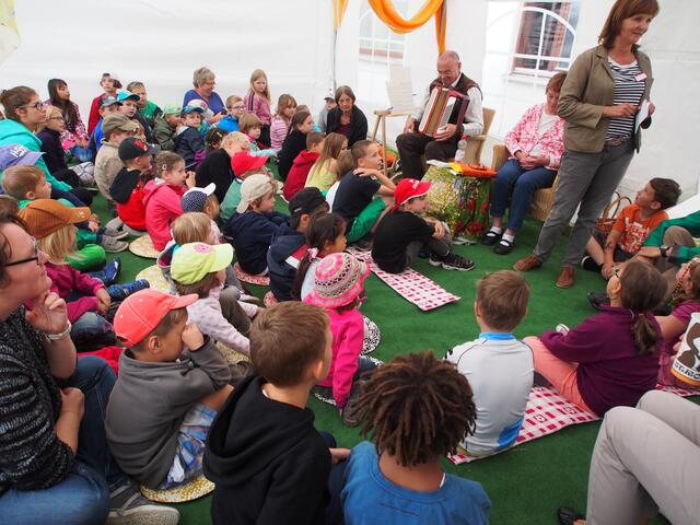 Psychologin Beatrix Melis (stehend), Mitarbeiterin der Sozialtherapeutische Einrichtungen, begrüßt Landsberger Kindern im Märchenzelt.