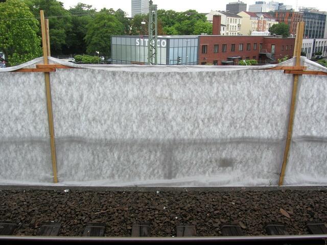 Ein Schutzzaun soll vor bei den Bauarbeiten aufgewirbelten Steinen und Staub schützen.