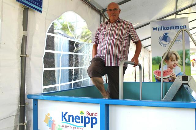 Gerold Barre, der Vorsitzende des niedersächsischen Kneipp-Landesverbands, demonstriert den Storchengang an der mobilen Wassertretstelle im Kneipp-Zelt.