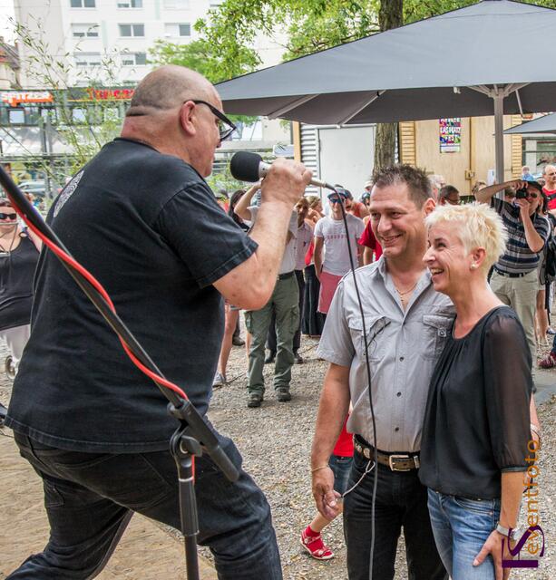 Helmut-Haller-Platz-Fest: Voll in Fahrt: Arno Löb - Impotenz-Band-Frontmann, Krimi-Autor, Kulturschaffender und Initiator der Widmung Helmut-Haller-Platzes. Im Bild: Arno Löb erklärt Sandra und Stefan Rummelhagen die psychischen Auswirkungen der Liebe