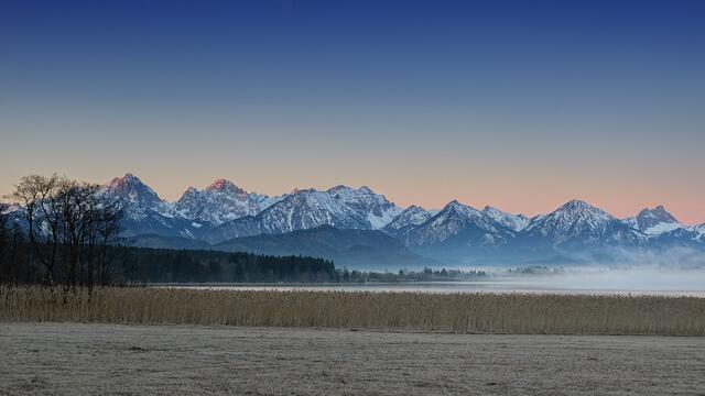 Algäuer Alpen mit Bannwaldsee im ersten Morgenlicht