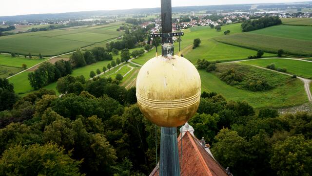Die goldene Kugel der Kirche Allerheiligen in Scheppach mit Blick über Jettingen-Scheppach