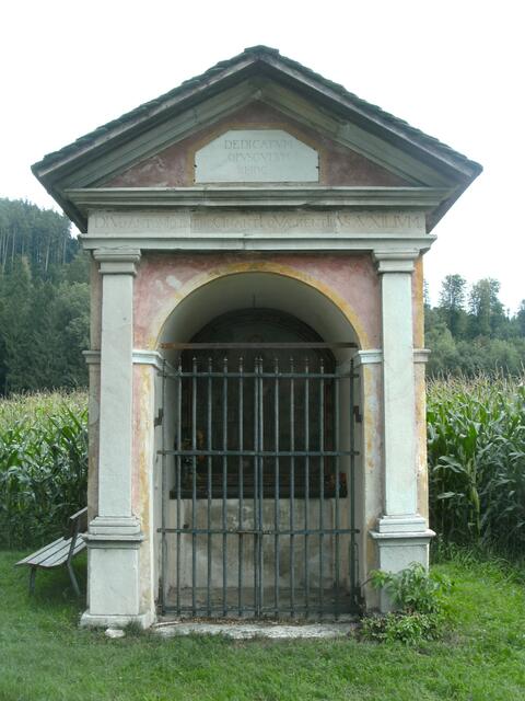 Prunnerkreuz mit eingemauerten Römischen Steinfragmenten.