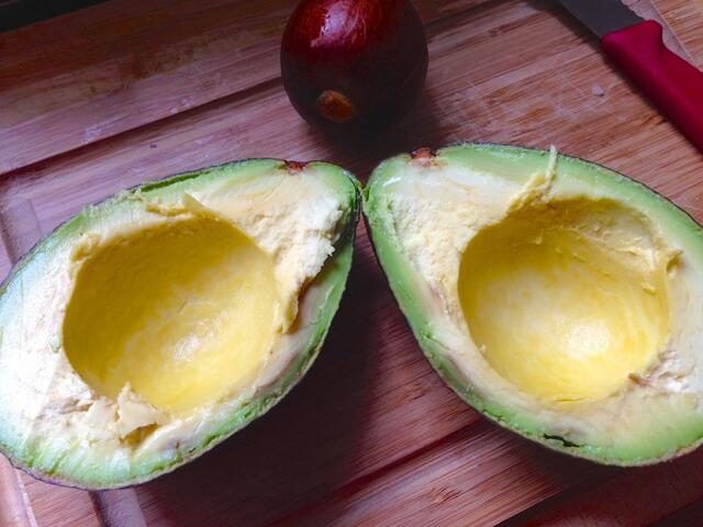 Avocado teilen und Kern entfernen - bei ganz reifen Früchten fällt der Kern von allein heraus