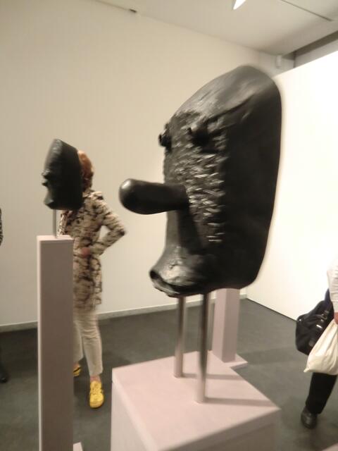 Die lange Nase einer japanischen Kyogen-maske durchstößt den Innenraum einer afrikanischen Maske