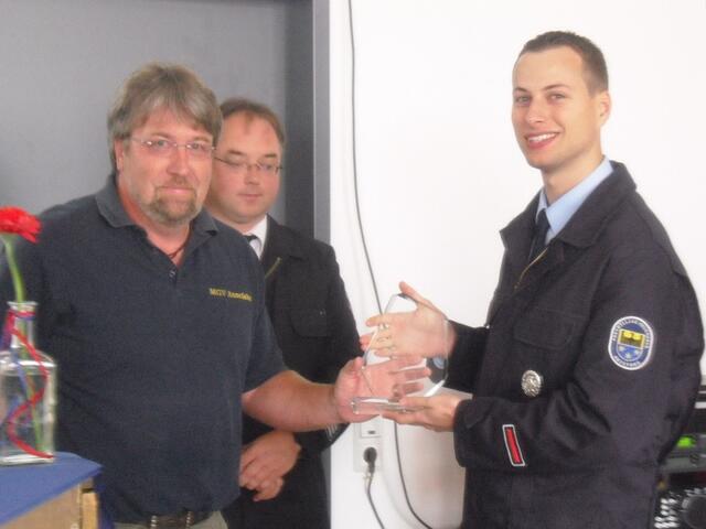 Der 1. Vorsitzende des MGV Elmar Dörr überreicht ein Präsent