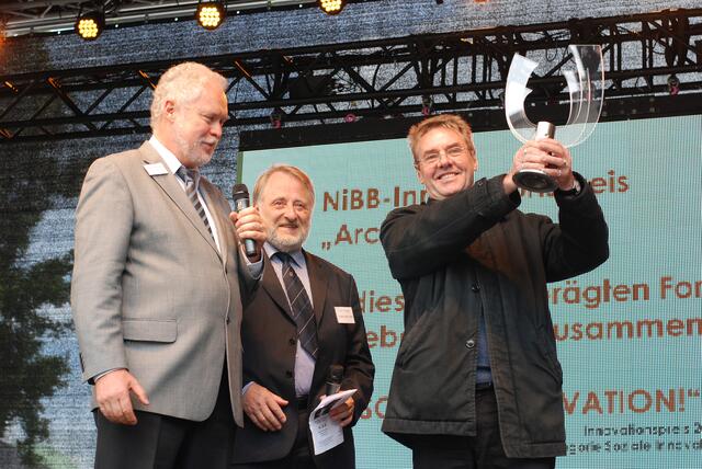 Prof. Dr.-Ing. Reinhard Spörer und OStr Hans-Georg Torkel übergeben den Preis an Pfarrer Willi Oberbeck: Es nimmt ihn für die "Arche Noah Essen" entgegen.