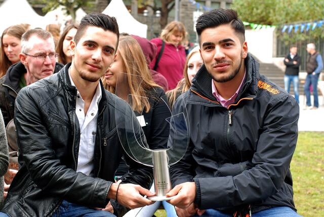Die Schüler Ibrahim Yilmatz und Luca Souag vom Erich-Brost-Berufskolleg nehmen den Pokal der Juniorschule-Essen stellvertretend als Schülerfirmenchefs entgegen.