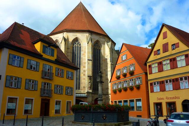 Brunnen mit Geranienschmuck und Münster St. Georg