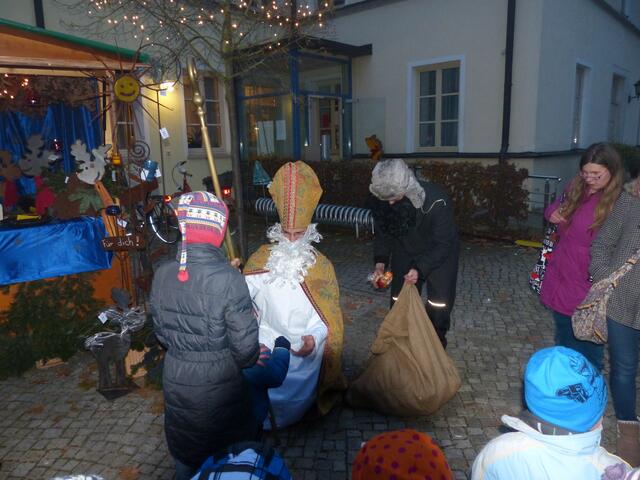 Der Nikolaus verteilt Geschenke an die Kinder ....