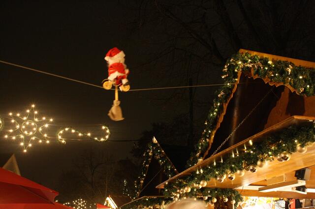 Augen nach oben: Auf einem Seil, das über die Straße gespannt ist, radelt ein Nikolaus.