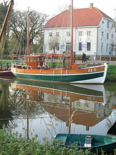Auf der Gegenseite der Segelkutter „Gebrüder AZ: 5“ vor dem Nationalparkhaus, in dem über das Wattenmeer informiert wird.