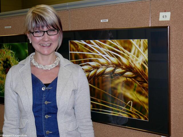 Ausstellerin Sandra Biegler mit ihrem Lieblingsbild "Kornfeld"