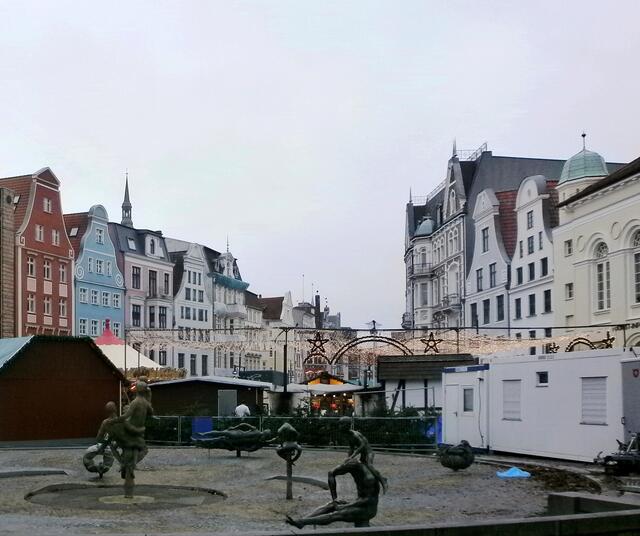 im Vordergrund der Brunnen der Lebensfreude auf dem Universitätsplatz.