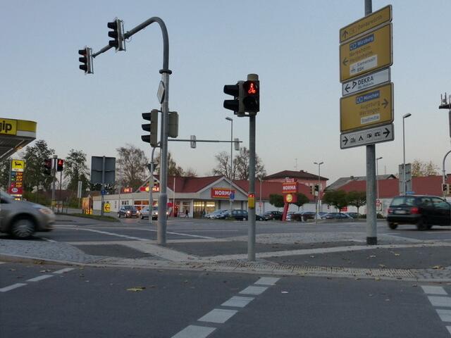 Nach dem Überqueren der Straße erwartet Dich ein leuchtender Anforderungstaster. Kein Grund zur Besorgnis, er hat nichts mit Dir zu tun. Er gilt für die Fußgänger auf der anderen Seite der Straße, die den "Klammergriff" anwenden sollen und müssen.