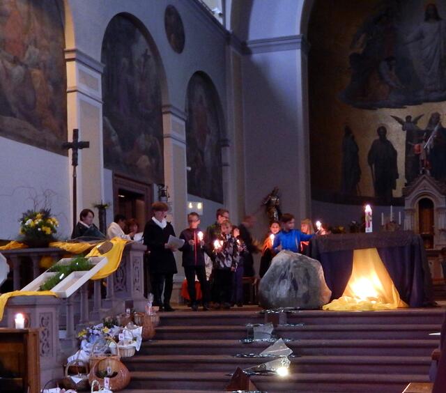 Jetzt stellen die Kinder auch ihre brennenden Kerzen auf den Altar Halleluja