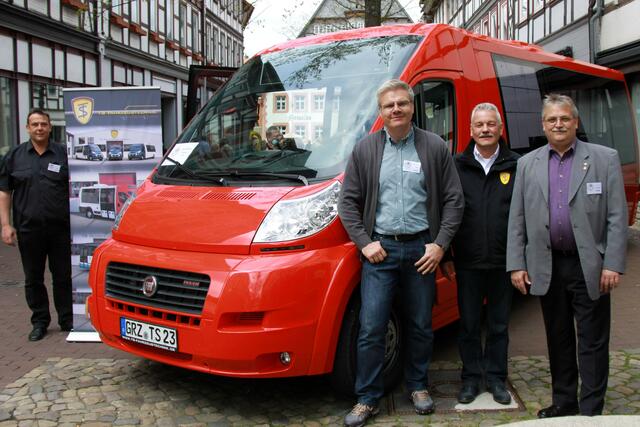 Bernd Hausmann, Jon Döring, Dietmar Vent(TS Fahrzeugtechnik GmbH) und Klaus Richard Behling stellen einen Bürgerbus in Osterodes Fußgängerzone einem breiten Publikum vor.
