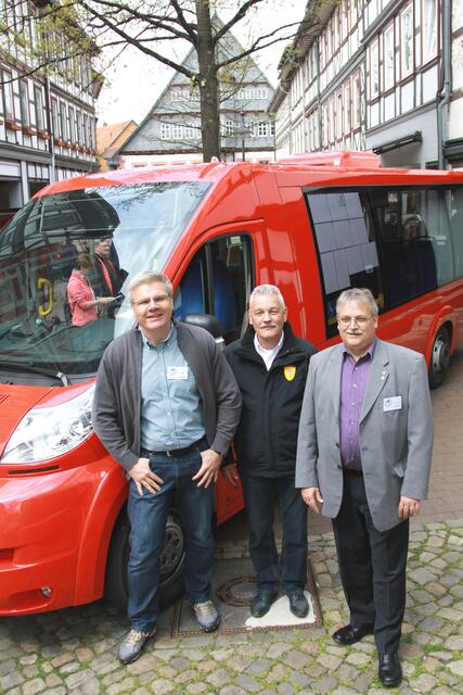 Jon Döring, Dietmar Vent(TS Fahrzeugtechnik GmbH) und Klaus Richard Behling stellen einen Bürgerbus in Osterodes Fußgängerzone einem breiten Publikum vor.