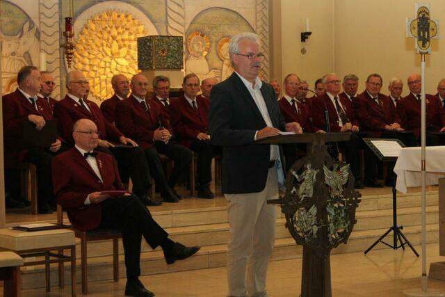Der Ortsbürgermeister Wolfgang Langrehr hat Glückwünsche und ein Flachgeschenk dabei.