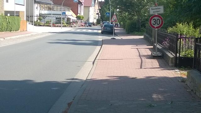 Gronau (Leine) ÜWL links beim Überweg 17.06.15: Wochen nach der Neubaufertigstellung liegt noch Baudreck in den Gossen der Bahnhof- und Dr.Georg Sauerweinstraße und 2 Verkehrsschilder "30Kmh Baustellenausfahrt"  und "Baustelle" sind wohl vergessen worden?