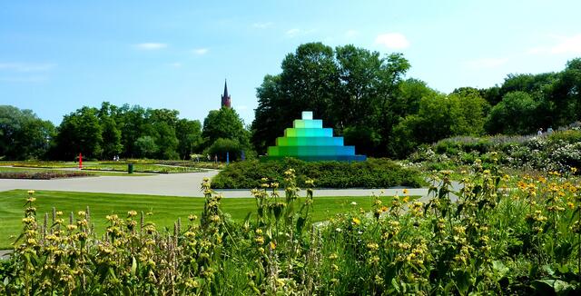 Farbpyramiden fügen sich in die Parklandschaft ein und gestalten sie.