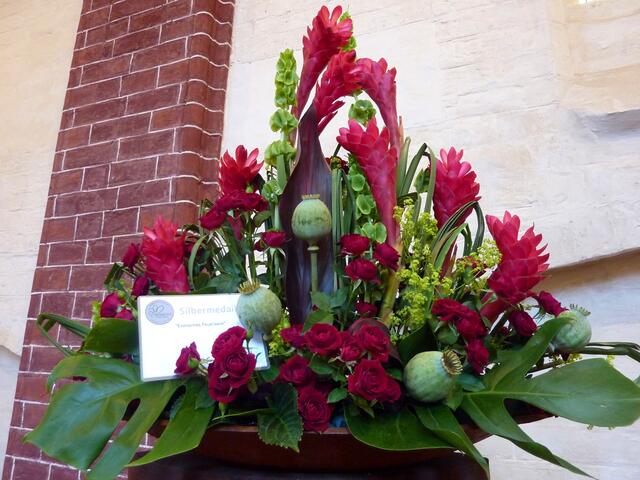 Verschiedene Blumen, aber alle in einer Farbe in einem attraktiven Gesteck