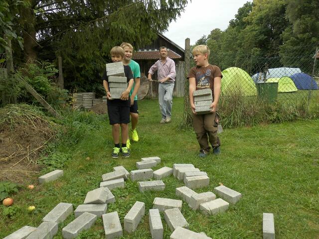 Die starken Jungs tragen die schwerzen Steine.