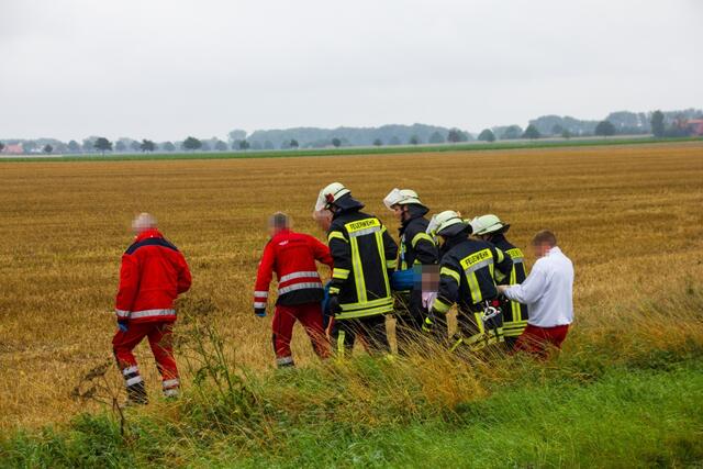 Eine verletzte Person wird zum Rettungshubschrauber der DRF getragen.