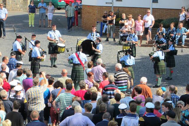 Dudelsäcke, Trommeln und Pfeifen spielen auf.