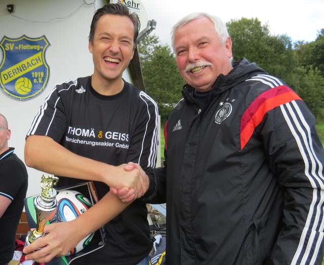 Kreisfußballwart Heinz Schmidt überreicht den Pokal und einen Ball an den Kapitän des Siegerteams von der SG Holzhausen-Steinperf