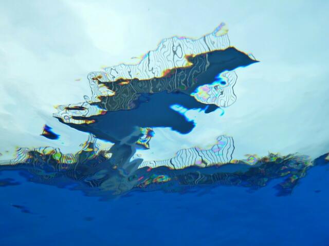 Zehnmeter-Sprungturm im Freibad der Genossenschaft Hänigsen. Die Kamera befindet sich in zwei Meter Wassertiefe. Zusätzlich Effekte werden von der untergehenden Sonne erzeugt. Das untere Drittel ist bedingt durch den Grenzwinkel der Totalreflektion nicht durch- „sichtig“. Neben der Komprimierung wurde keine Bearbeitung des Fotos durchgeführt.