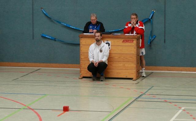 DBS-Schiedsrichter Jan Beck ( hockend) beobachtet den korrekten Spielverlauf. Im Hintergrund die beiden Mannschaftsführer von Nienburg (links) und Hameln (rechts). www.bsg-anderten.de