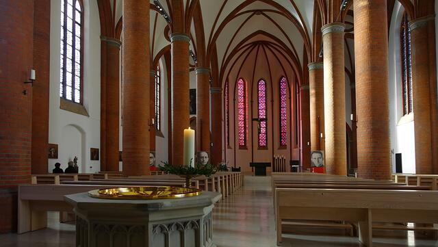 Eine zentrale Achse der Kirche bilden das neugotische Taufbecken und der Altar, sie beziehen sich auf die Sakramente Taufe und Eucharistie. Hinter dem Taufbecken steht der Osterleuchter von 1724 aus Messing. Foto: Helmut Kuzina