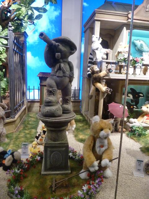 Herr Bär harkt eifrig den Rasen.