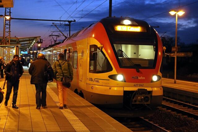 Ein dreiteiliger HLB-FLIRT fährt nach Kassel. Zwei Reisende steigen vom Zug nach Marburg in den Zug nach Kassel um (14.12.2015).