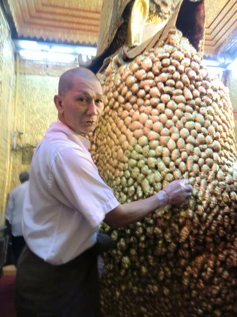 Die Buddhafigur selbst mit kleinen Blattgoldstückchen zu belegen verschafft gutes Kharma. Dem anderen zu helfen auch. Schweigend fordert mich der Mann auf, eines seiner zuvor gekauften Goldhäutchen auf dieStatue zu drücken.