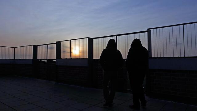 Warten auf den Sonnenuntergang; Sicherheitsstäbe umgeben die Aussichtsplattform. Foto: Helmut Kuzina