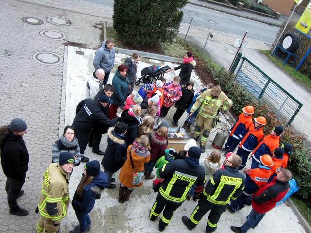 Die Kinder sowie die Eltern schauen sich gespannt die Experimente an