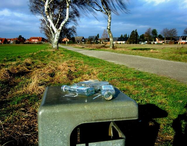 Die 25. Schnapsflasche innerhalb von drei Monaten glänzte verlockend in der Sonne. Die abgeschraubten Verschlüsse lockern derweil den Ackerboden auf.
