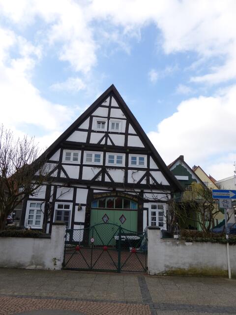 Typisches Ackerbürgerhaus mit der grünen Tür zur großen Diele. Aufschrift: "Dau wat du wult de Lüe snackt doch."