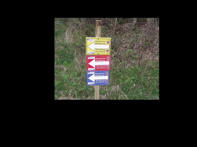 Verschiedenfarbige Wegweiser für jede Wanderstrecke: Die 6 km lange Wanderstrecke ist gelb, die 11 km lange Wanderstrecke ist rot und die 20 km lange Wanderstrecke ist blau markiert.