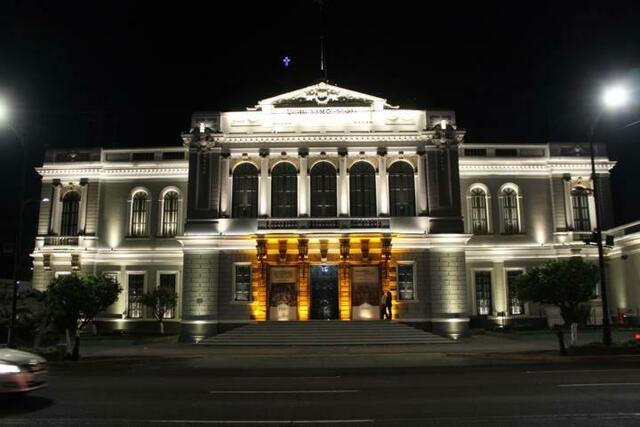Uni-Gebäude bei Nacht - Orientierung im nächtlichen Straßenverkehr bietet das blaue Kreuz des Templo Expiratorio im Hintergrund.