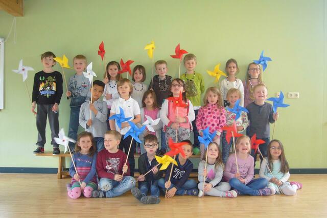 stolz präsentieren die Vorschulkinder ihre gebastelten Windräder