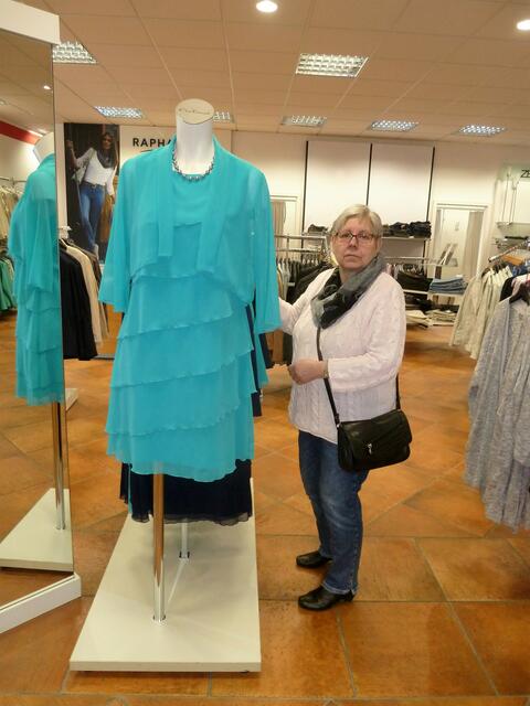 Eine Kundin bewundert das hübsche Kleid.