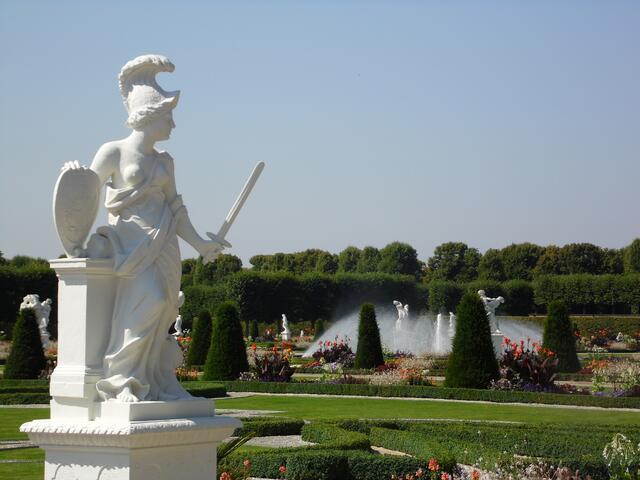 32 weiße Sandsteinfiguren sind zu Themenbereichen angeordnet. An den Ecken Skulpturen, die die Kontinente Europa, Asien Afrika und Amerika vertreten. Diese kriegerische Dame vertritt Europa.